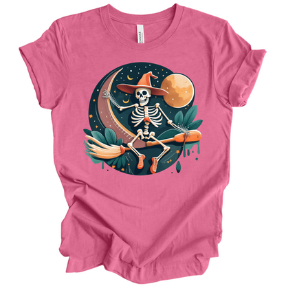 Pink halloween t-shirt with a skeleton on a broomstick wearing a witch hat in the night time.