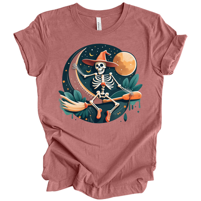 Pink halloween t-shirt with a skeleton on a broomstick wearing a witch hat in the night time.