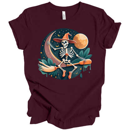 Maroon halloween t-shirt with a skeleton on a broomstick wearing a witch hat in the night time.