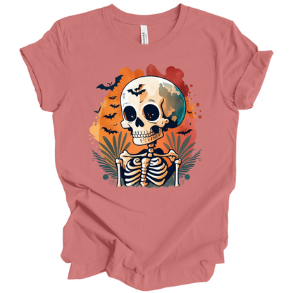Pink t-shirt with a Halloween-themed design featuring a skeleton and skull surrounded with bats.