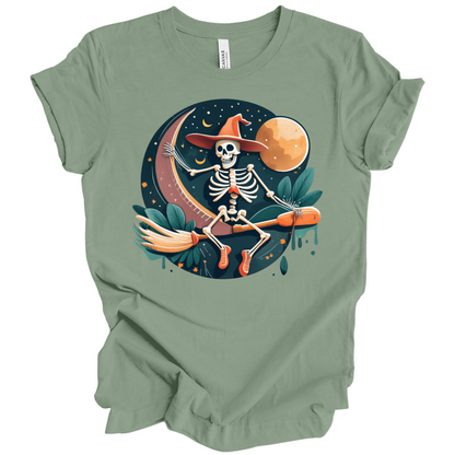 Green halloween t-shirt with a skeleton on a broomstick wearing a witch hat in the night time.