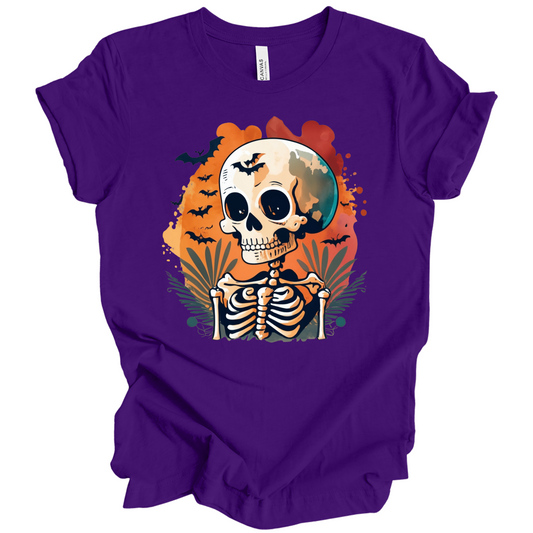 Purple t-shirt with a Halloween-themed design featuring a skeleton and skull surrounded with bats.