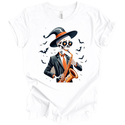 White halloween t-shirt with a skeleton playing a saxophone and wearing a witch hat, surrounded by bats.